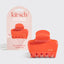 Orange hair clip with packaging displaying 'kitsch' brand on a light gray background