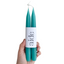 Two teal candles held by a hand with a white label displaying 'aide' on a white background