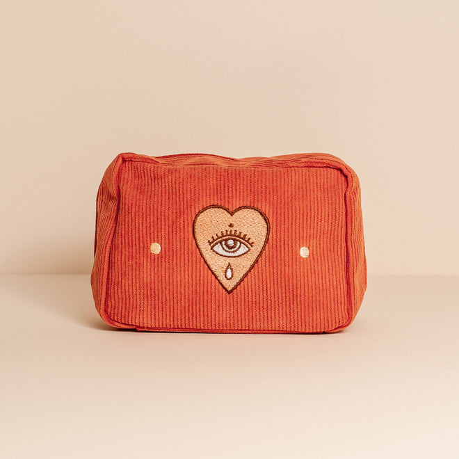 makeup bag in rust with a eye and heart embroidery 
