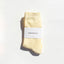 Pair of yellow socks with a 'Bondoodle' label on a white background