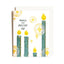 A greeting card with a white envelope, featuring a festive illustration of teal and yellow candles, gold glittery starbursts, and the text 'MAKE THE YULETIDE GAY' on a white background.