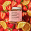 Jar of 'Strawberry Sencha Lemonade' tea blend surrounded by strawberries and lemon slices.