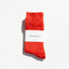Red sock with a white label on a light gray background