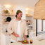 Man in a kitchen holding a lime and a glass of iced coffee