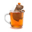 Tea infuser shaped like a beaver in a glass of tea on a white background