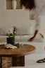 Living room with a wooden coffee table, sofa, and decorative items.