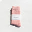 Pink sock with a white label on a light gray background