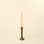 Decorative candle holder with a lit candle on a beige background