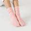 Person wearing pink socks on a light gray background