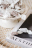 Candies wrapped in white paper on a book titled 'AESTHETIC' with a woven surface background.