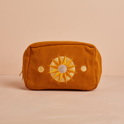 rust coloured corduroy makeup bag with embroidered sun