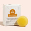 Yellow conditioning bar and packaging of 'good juju' on a light pink background