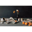 Set of ceramic bowls and a spoon on a textured surface with a dark background