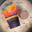 Gnar Hot Chocolate Flakes packaging with a cup of hot chocolate on a wooden surface