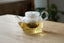 Glass teapot with tea on a wooden surface, featuring the Shihoyama brand.