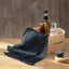 Bathroom set with a wooden bucket, bottles, and a towel on a wooden surface.