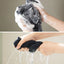 Person washing a black cloth with soapy water and then rinsing it under running water.