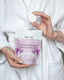 Person holding a container of Naturebee Shower Steamers with a white bathrobe background
