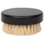 Round brush with black handle and beige bristles on a white background