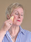 women holding gua sha tool to face