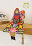 Colorful butterfly-shaped figurine with a heart design on a wooden surface, branded 'Butterfly Women by Kitty Kenda'.