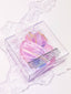 Pink crystal in a clear box on a marble surface