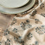 Floral-patterned cloth on a wooden table with ceramic plates.