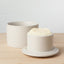 Two white ceramic bowls on a wooden surface with a light gray background