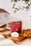 good jiju shampoo bar on a wooden tray with a glass of water and a sponge.