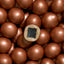 Close-up of a small square object embedded in a cluster of brown spherical objects.