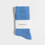Pair of blue socks with a white label on a light gray background