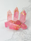 Pink crystal towers with gold accents on a marble surface