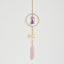 Crystal pendant with gold chain on a light gray background
