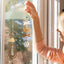 Person hanging decorative window hangings on a glass door
