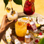 Assorted cocktails on a tray with 'Pina Colada' and 'San Juan Salsa' bottles.
