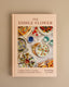 The Edible Flower cookbook by Erin Burting and Jo Facer, featuring a light peach cover with a central photograph of various edible flowers and dishes, displayed on a neutral beige background.