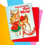 A vintage-style Christmas greeting card featuring an illustration of a young girl in a red coat hugging a deer, with the text 'I have deemed you Card Worthy!' and 'Merry Christmas!' on the card. The card is layered over red and pink envelopes on a bright multicolor background.
