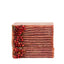 Stack of red soap bars with natural elements on a white background
