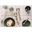 Table setting with ceramic plates, silver cutlery, and glasses on a tiled surface.