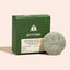Nourishing shampoo bar with green packaging labeled 'good juju' on a beige background
