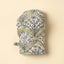 Pair of oven mitts with leaf pattern on a beige background