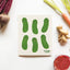 Notebook with pickle illustrations on a table with vegetables