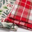 Stack of fabric sheets with Christmas-themed patterns on a white background