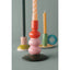 Colorful candle holder with a twisted candle on a gray background