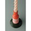 Colorful candle with a red wick holder on a gray background