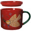 Red mug with angel design and green handle on a white background
