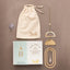 Suncatcher with packaging and 'Scout' branded drawstring bag on a brown background