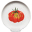 A white ceramic plate featuring a painted red tomato with green and yellow highlights in the center, set against a plain white background.