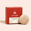 Volumizing shampoo bar with red packaging featuring 'good juju' brand on a beige background