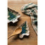 Two ceramic dishes with tree design and a wooden spoon on a wooden surface with a plaid cloth.